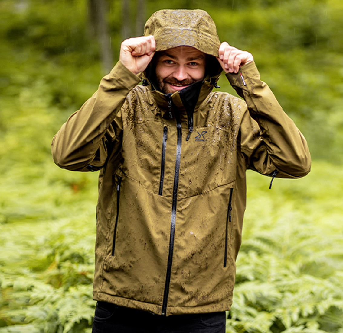 man in forest standing in rain - cyclone rescue jacket green.jpg